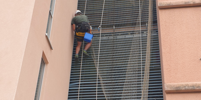 Monterska ekipa namešča zaščitno mrežo na fasado